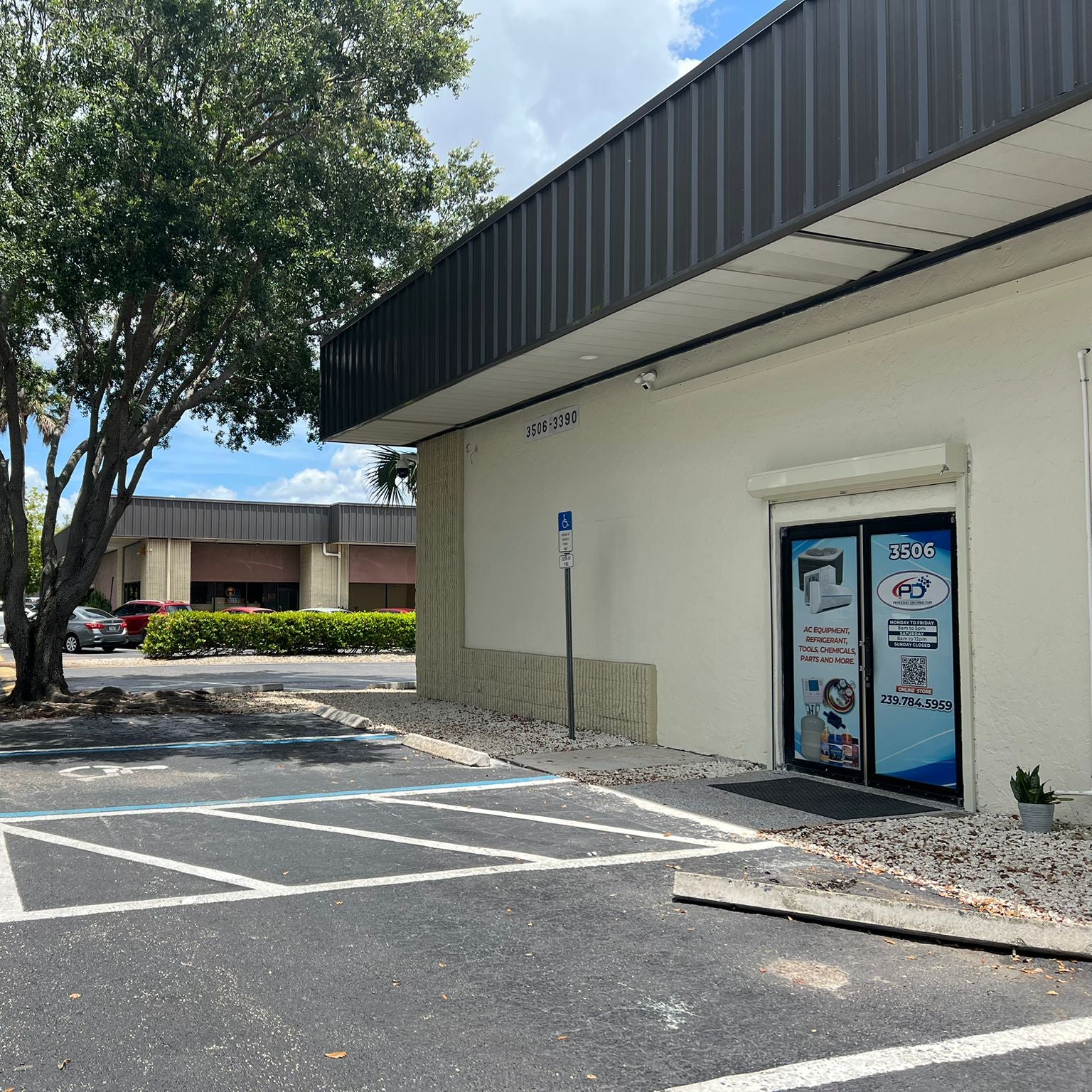 Commercial building with a parking lot and trees on a sunny day